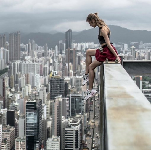 고층건물 옥상 란간서 사진 찍는 미녀